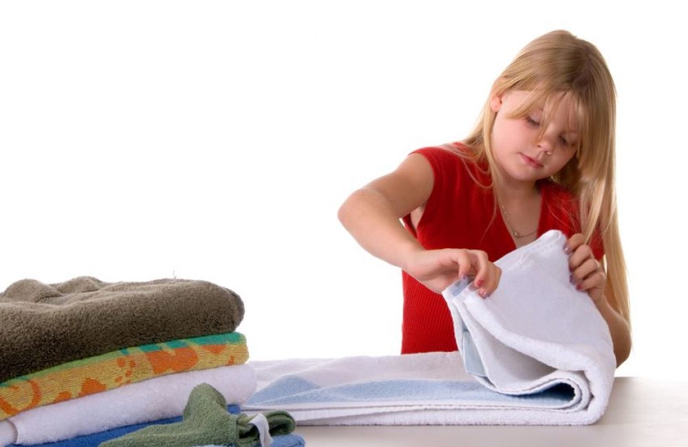 966855 - young girl helping with laundry folding towels